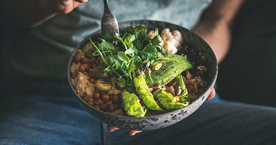 Buddha bowl with hummus, vegetable, salad, beans, couscous and avocado